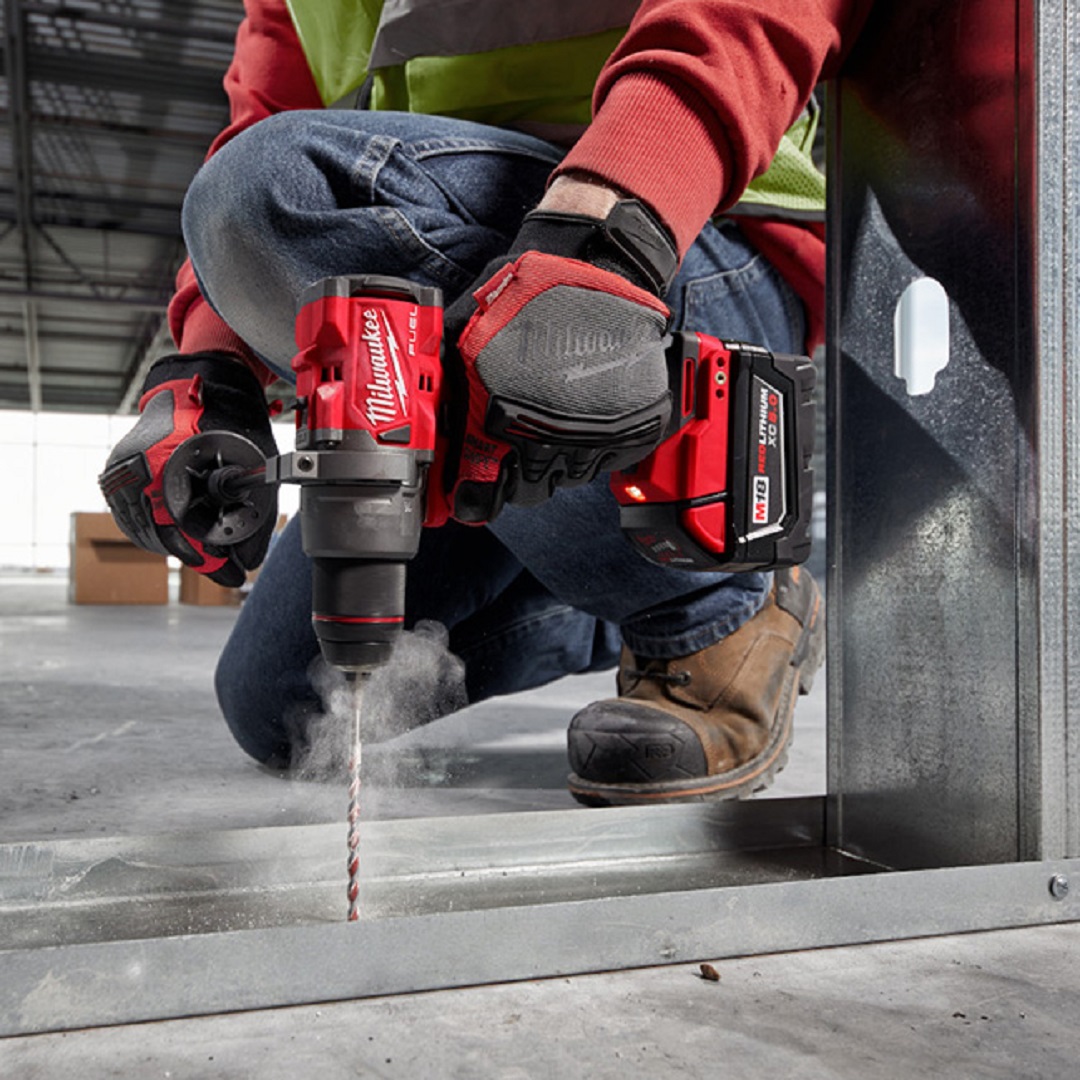 Profissional perfura estrutura metálica com ferramenta Milwaukee